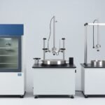 Three environmental testing devices sit side by side in the lab: a climatic chamber, a large vibration table, and a drop tester