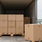 Pallet hàng và thùng carton tại bến bốc xếp có xe tải mở cửa — minh hoạ thử nghiệm ISTA 3B cho hàng ghép chuyến (LTL)