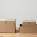 Hai phương án bao bì đặt cạnh nhau: một thùng carton nâu không nhãn có nhãn vận chuyển, và một hộp nhỏ đặt trong hộp ngoài lớn có vật liệu chèn — ảnh bìa so sánh SIOC và Over Boxing